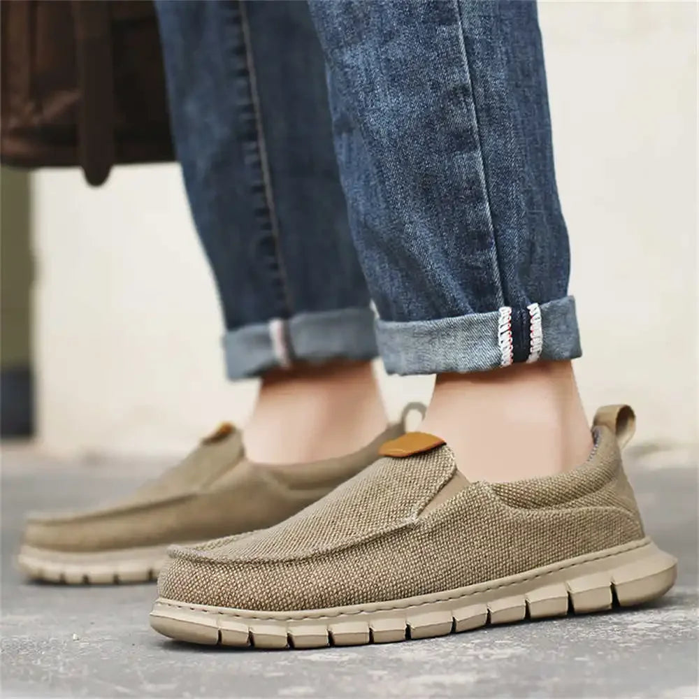 Beige Herren-Sneaker aus Leinen, kombiniert mit hochgekrempelten blauen Jeans. Bequeme Freizeitschuhe für den Alltag.