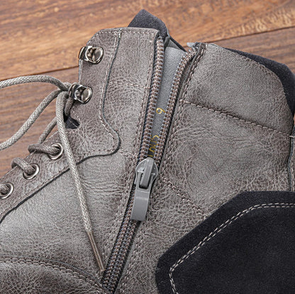 Grauer Lederstiefel mit Reißverschluss und Schnürsenkeln auf Holzboden. Robustes Design, ideal für Outdoor-Aktivitäten und modische Herbst-Looks.