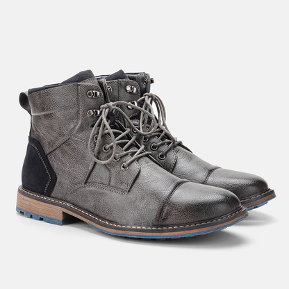 Graue Herren-Lederstiefel mit Schnürung, robustem Design und blauer Sohle. Modische, strapazierfähige Boots für Herbst und Winter.