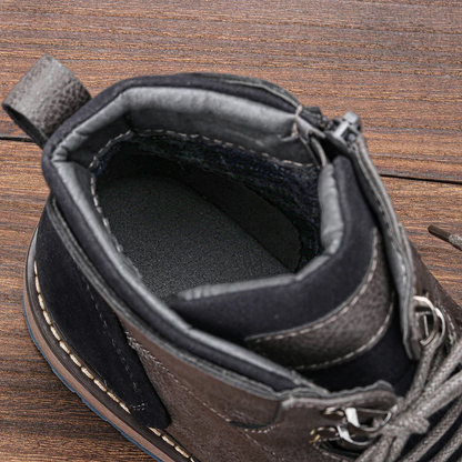 Hochwertiger schwarzer Lederstiefel mit robustem Design, seitlichem Reißverschluss und gepolstertem Innenfutter auf Holzhintergrund.