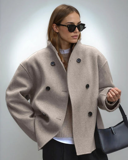 Frau mit beiger Wolljacke, schwarzer Sonnenbrille und schwarzer Handtasche. Modetrend Herbst, stilvolle Damenbekleidung, elegante Accessoires.