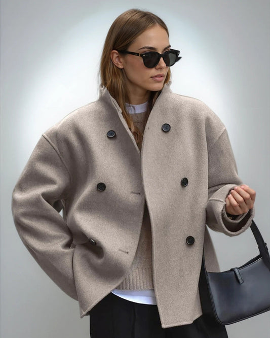 Frau mit beiger Wolljacke, schwarzer Sonnenbrille und schwarzer Handtasche. Modetrend Herbst, stilvolle Damenbekleidung, elegante Accessoires.