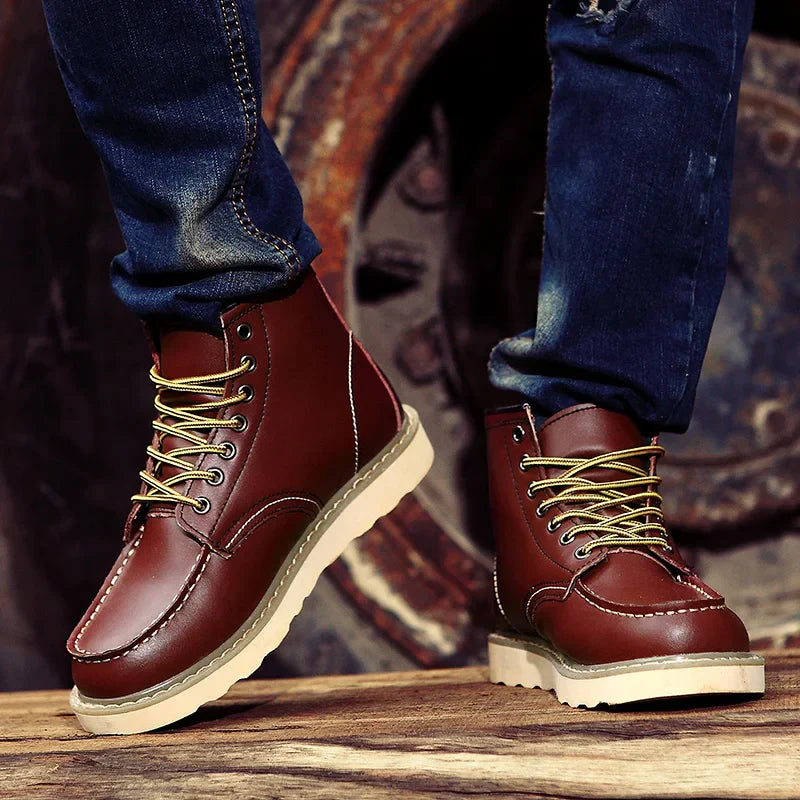 Braune Lederstiefel mit gelben Schnürsenkeln, getragen von Person in blauen Jeans. Modische Herrenstiefel, robustes Design, Outdoor-tauglich.