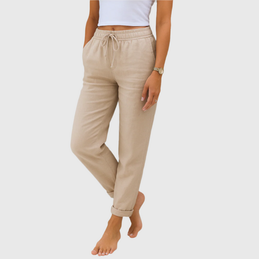 Frau trägt beige Leinenhose mit Kordelzug und weißem Top. Modische Damenbekleidung, lässiger Stil, ideal für Sommer und Freizeit.