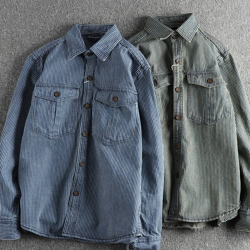 Zwei gestreifte Hemden aus Baumwolle, blau und grün, mit Brusttaschen und Knöpfen, auf grauem Hintergrund. Herrenmode, Freizeitkleidung.
