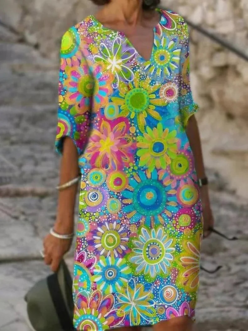 Buntes Sommerkleid mit Blumenmuster, leuchtende Farben, knielang, V-Ausschnitt, ideal für Strandmode und Freizeitkleidung.