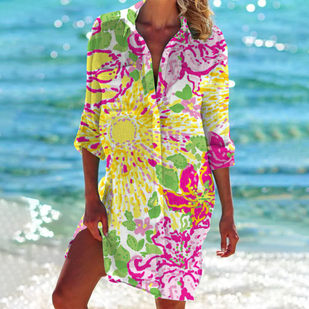 Frau in buntem, geblümtem Strandkleid am Meer. Sommermode, Strandkleidung, Urlaub, tropisches Design, Freizeitkleidung.