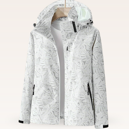 Weiße Damen-Windjacke mit Kapuze, floralem Muster und Reißverschlusstaschen. Ideal für Outdoor-Aktivitäten und modische Freizeitkleidung.