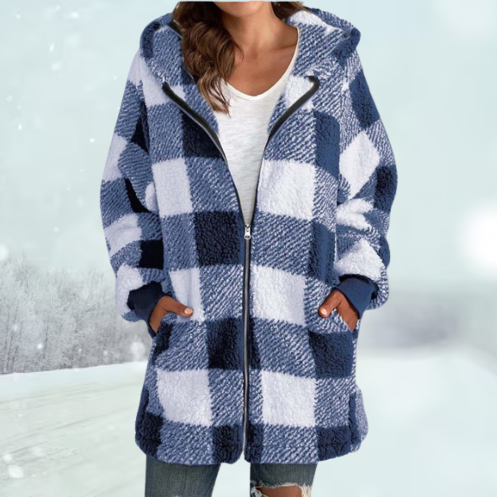 Frau in blau-weiß kariertem Fleece-Mantel mit Kapuze, Wintermode, gemütlicher Outdoor-Look, schneebedeckter Hintergrund, modische Damenbekleidung.