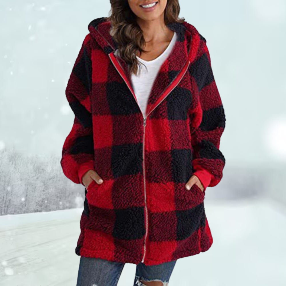 Frau in rotem karierten Fleece-Mantel, Winterlandschaft im Hintergrund, modische Winterkleidung, gemütlicher Look, Outdoor-Mode.