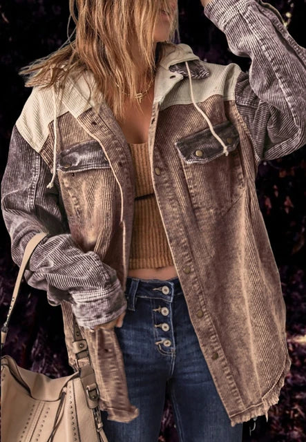 Frau in modischer Cordjacke, kombiniert mit Jeans und beiger Handtasche. Trendige Herbstmode, lässiger Streetstyle-Look.