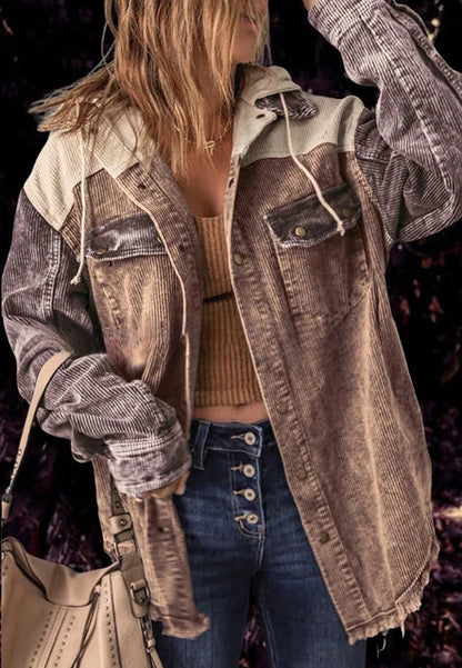 Frau in modischer Cordjacke, kombiniert mit Jeans und beiger Handtasche. Trendige Herbstmode, lässiger Streetstyle-Look.
