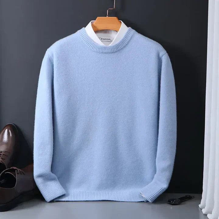 Hellblauer Pullover aus Kaschmir auf Kleiderbügel, kombiniert mit weißem Hemd. Elegante Herrenmode, ideal für Herbst und Winter.