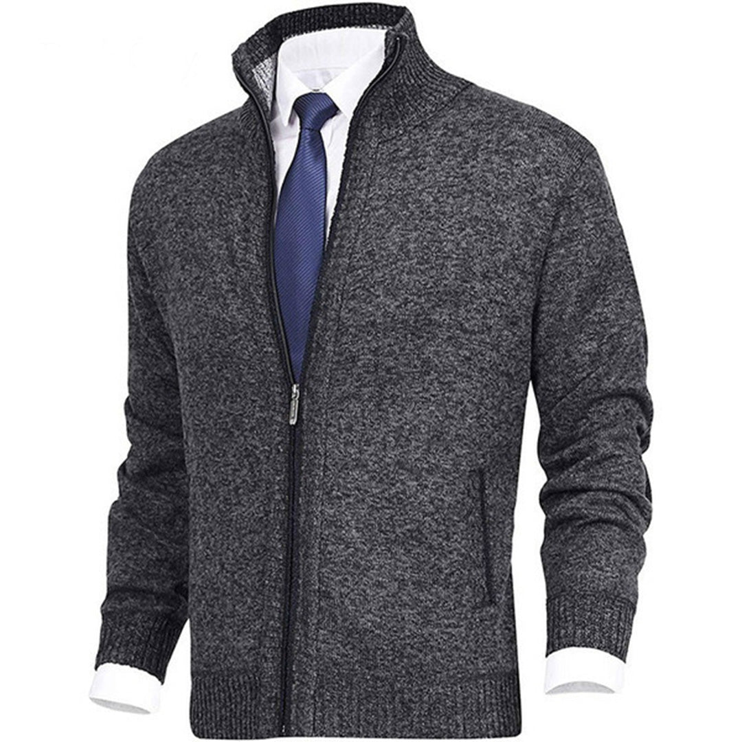 Grauer Herren-Strickjacke mit Reißverschluss, kombiniert mit weißem Hemd und blauer Krawatte. Elegante, warme Mode für Büro und Freizeit.