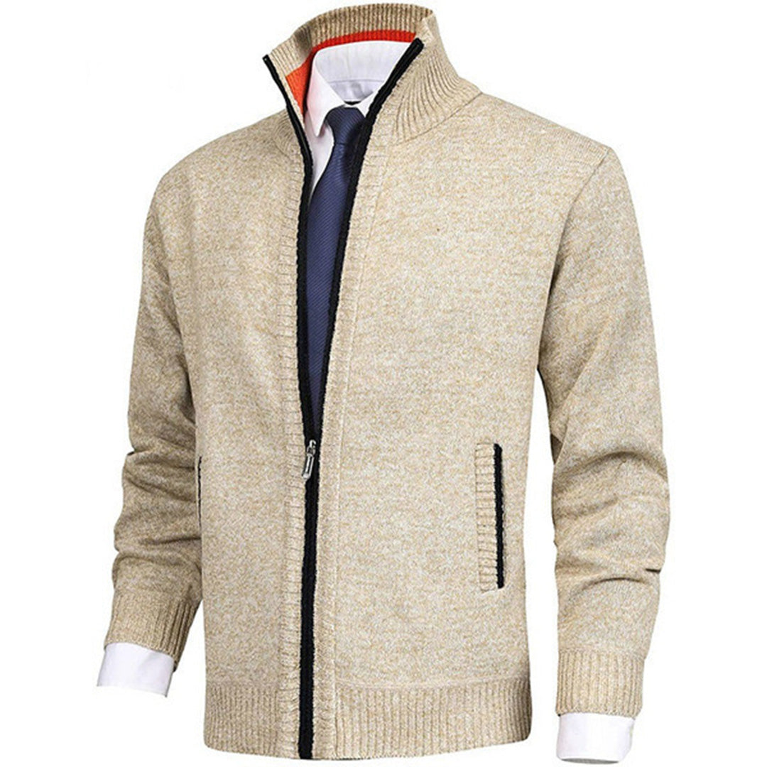 Beige Herren-Strickjacke mit Reißverschluss, kombiniert mit weißem Hemd und dunkelblauer Krawatte. Elegante, modische Herrenbekleidung.