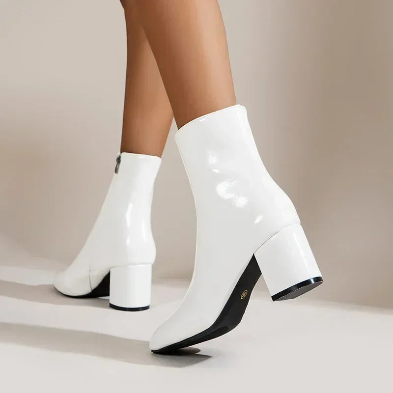 Weiße Damenstiefeletten mit Blockabsatz, glänzendem Finish und seitlichem Reißverschluss. Modische Schuhe für Herbst und Winter.
