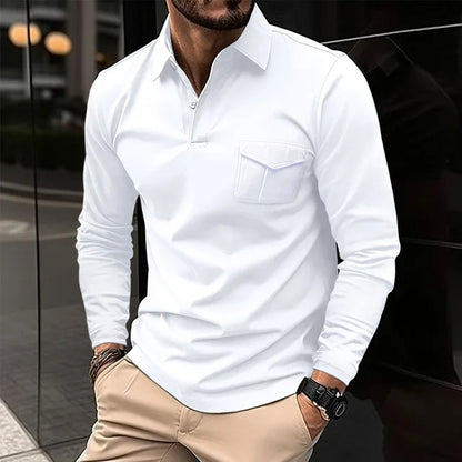 Mann in weißem Langarmhemd und beigen Chinos, steht lässig mit einer Hand in der Tasche. Stilvolle Herrenmode, urbaner Hintergrund.