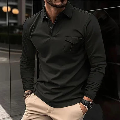 Mann in schwarzem Langarm-Poloshirt und beigen Hosen lehnt an einer Wand. Stilvolle Herrenmode, Freizeitlook, urbane Umgebung.