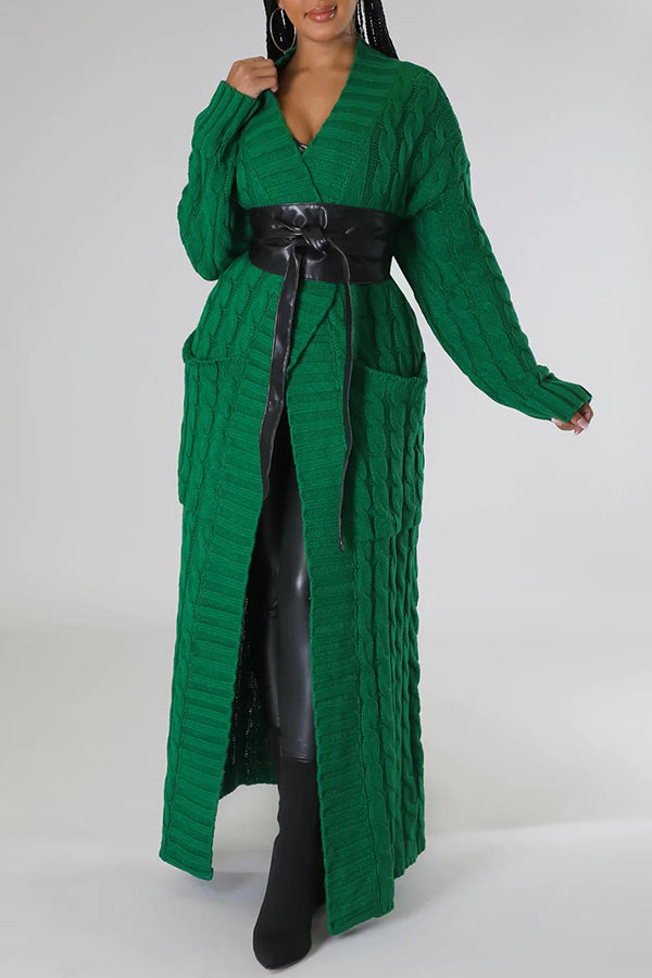 Frau in langem, grünem Strickmantel mit Gürtel, schwarze Stiefel. Modetrend, Damenmode, eleganter Winterlook, Strickmode, stilvoller Mantel.