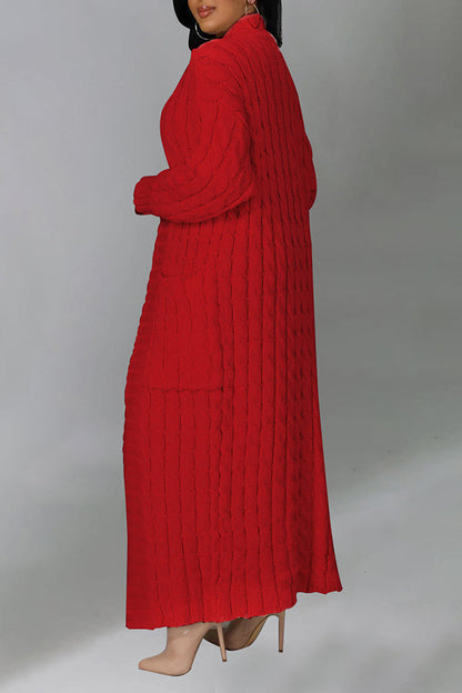 Frau in langem, rotem Strickkleid mit Zopfmuster, seitlich stehend, trägt beige High Heels. Elegante Mode, Winterkleidung, Damenbekleidung.