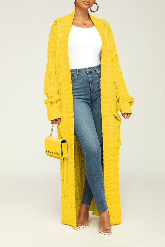 Frau in gelbem Strick-Cardigan, weißem Top und blauer Jeans, trägt gelbe Handtasche. Modetrend, Herbstmode, Damenbekleidung, Streetstyle.