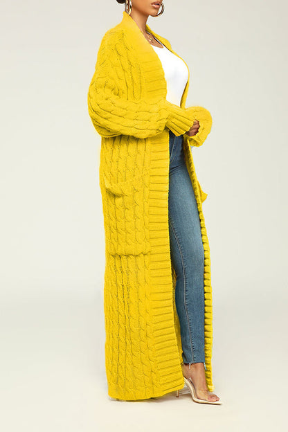 Frau in gelbem Strick-Cardigan, weiße Bluse, blaue Jeans und transparenten High Heels. Modetrend, Herbstmode, Damenbekleidung, Strickjacke.