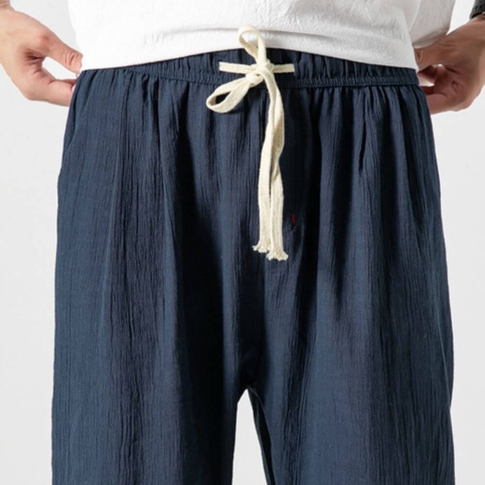 Dunkelblaue Herren-Leinenhose mit Kordelzug, lässiger Stil, ideal für Sommermode. Bequeme Passform, atmungsaktives Material, trendige Freizeitkleidung.