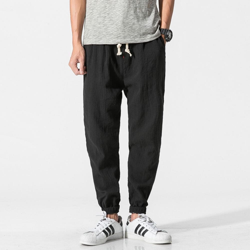 Graue Jogginghose für Herren, lässig und bequem, kombiniert mit weißen Sneakers. Ideal für Freizeit und Sport. Hochwertige Herrenmode.