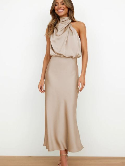 Elegantes, ärmelloses, beiges Satinkleid mit hohem Kragen, bodenlang, getragen von einer lächelnden Frau. Perfekt für Abendveranstaltungen.