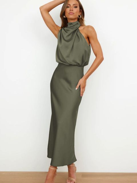 Frau in elegantem, olivgrünem Satinkleid mit hohem Kragen und ärmellosem Design, posiert vor weißem Hintergrund. Abendmode, Damenkleidung, stilvoll.