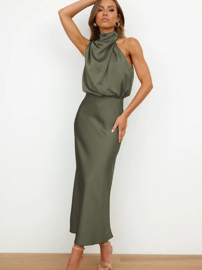 Frau in elegantem, olivgrünem Satinkleid mit hohem Kragen und ärmellosem Design, posiert vor weißem Hintergrund. Abendmode, Damenkleidung, stilvoll.