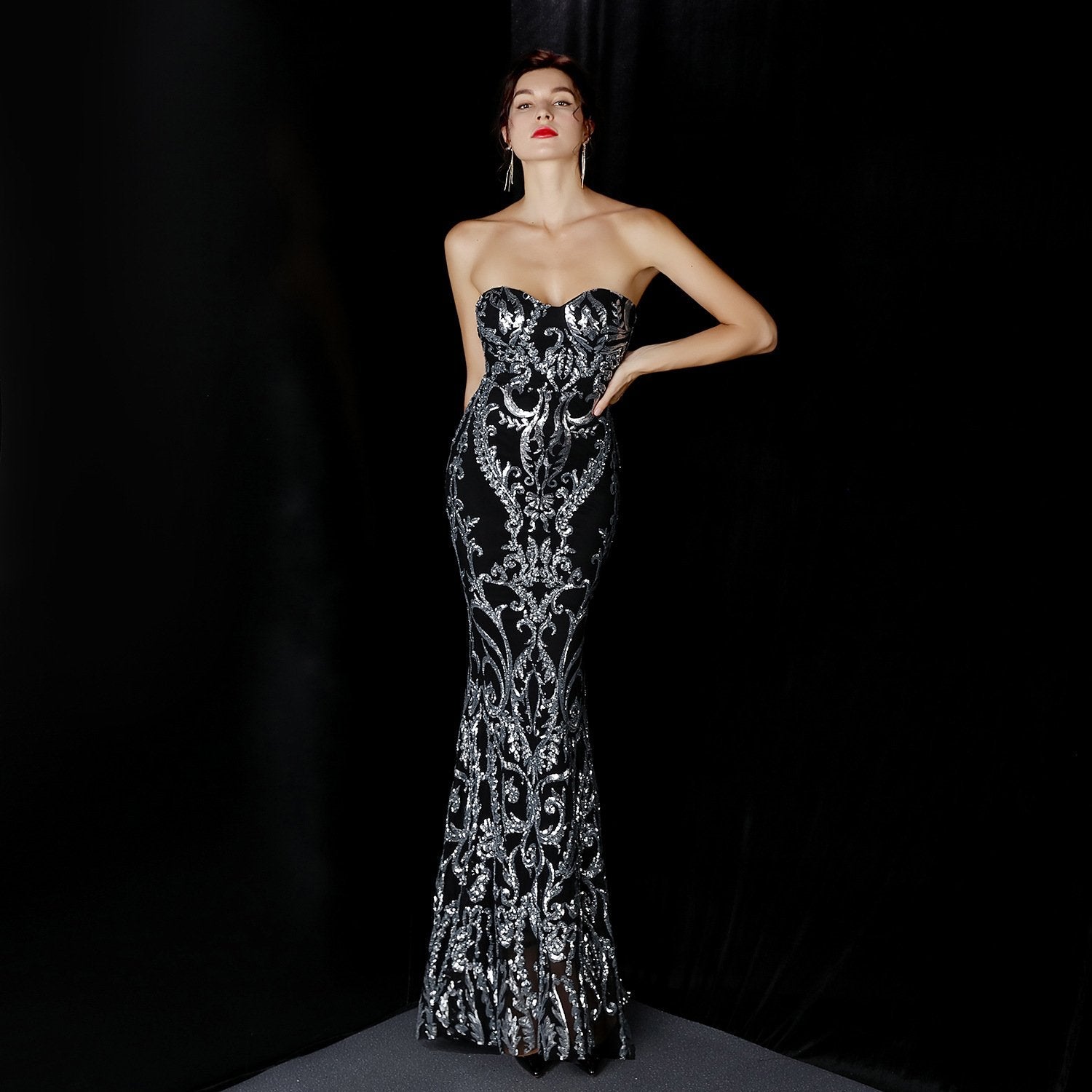 Elegantes schwarzes Abendkleid mit silbernen Verzierungen, trägerloses Design, figurbetont, ideal für formelle Anlässe und Galas.