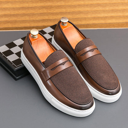 Braune Herren-Slipper aus Leder mit weißer Sohle auf grauem Hintergrund, stilvoll und modern, ideal für elegante Freizeitoutfits.
