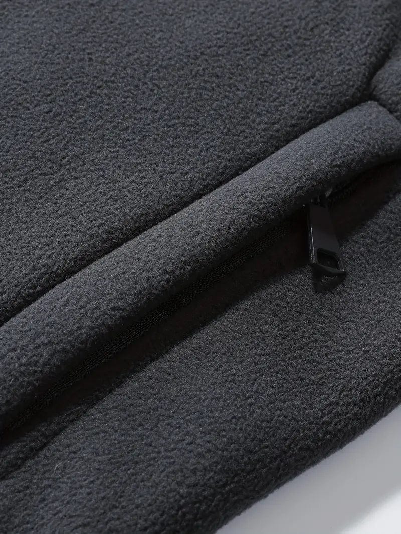 Dunkelgraue Fleecejacke mit Reißverschluss, Nahaufnahme. Weiches, warmes Material, ideal für Outdoor-Aktivitäten und kaltes Wetter.