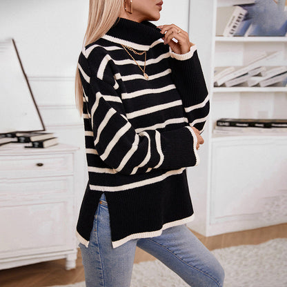 Frau in gestreiftem Rollkragenpullover, schwarz-weiß, trägt Jeans, steht in modernem Wohnzimmer. Modetrend, Herbstmode, gemütlicher Look.