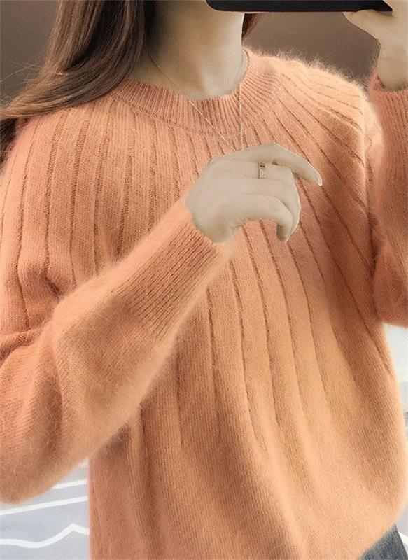 Frau trägt weichen, orangefarbenen Strickpullover, Nahaufnahme. Modetrend, Herbstmode, Damenbekleidung, gemütlicher Pullover, Strickmode.