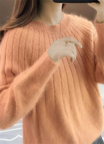 Frau trägt weichen, orangefarbenen Strickpullover, Nahaufnahme. Modetrend, Herbstmode, Damenbekleidung, gemütlicher Pullover, Strickmode.