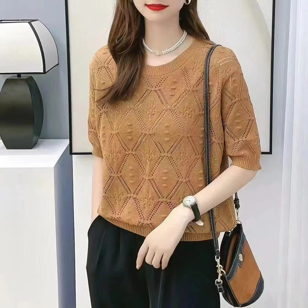 Frau trägt braunen Strickpullover mit Diamantmuster, schwarze Hose, schwarze Umhängetasche und Armbanduhr. Elegante Mode, Herbstoutfit.