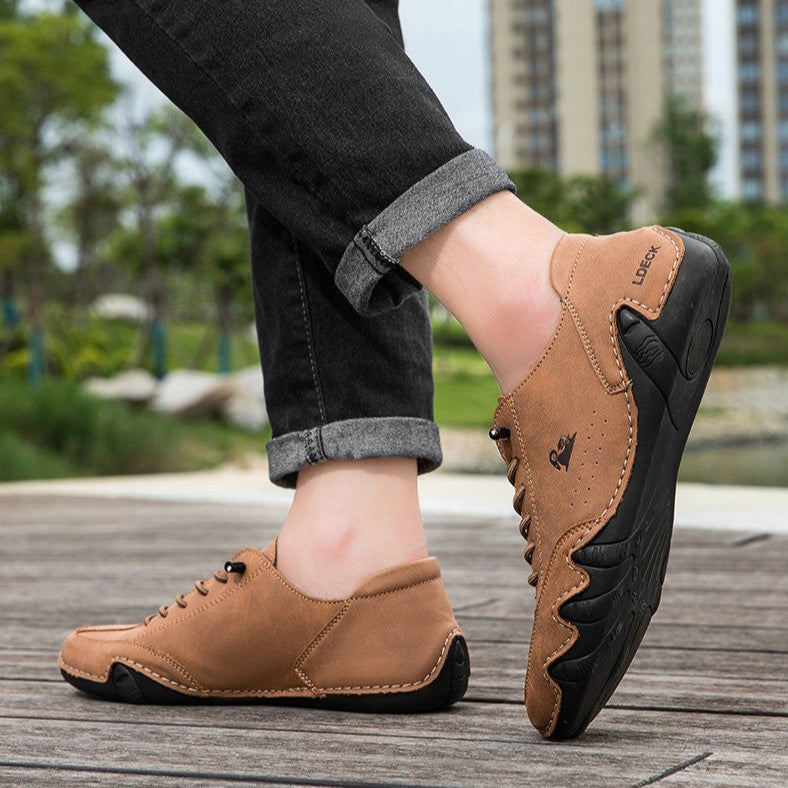 Braune Herren-Freizeitschuhe aus Leder, getragen von Person auf Holzsteg im Freien. Bequeme, stilvolle Schuhe für Alltag und Freizeit.