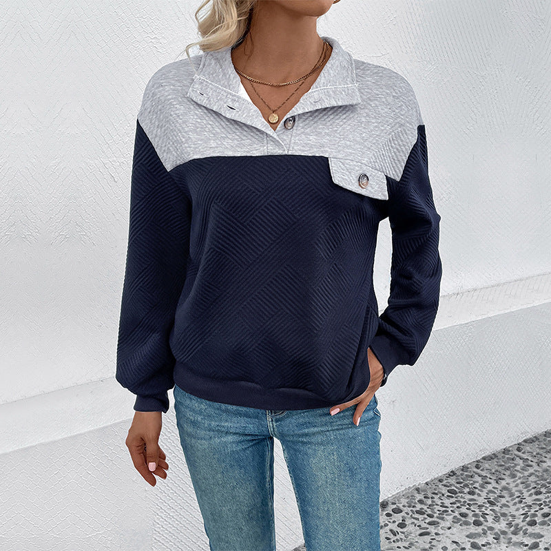 Frau in blau-weißem Pullover mit Knopfleiste und blauen Jeans vor weißer Wand. Modetrend, Damenbekleidung, Freizeitlook.
