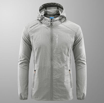 Graue Herren-Windjacke mit Kapuze, Reißverschluss und Taschen. Leichtes, atmungsaktives Material, ideal für Outdoor-Aktivitäten und Sport.