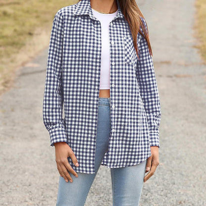 Frau in kariertem Hemd, weißem Top und blauer Jeans auf ländlichem Weg. Modetrend, Freizeitlook, Damenmode, kariertes Hemd, Outdoor-Stil.