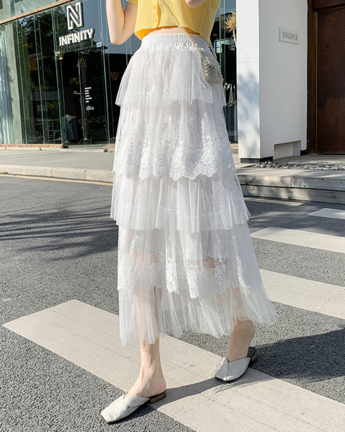 Frau in weißem, mehrlagigem Spitzenrock und gelbem Oberteil auf Gehweg. Modetrend, Sommeroutfit, eleganter Stil, Stadtmode.