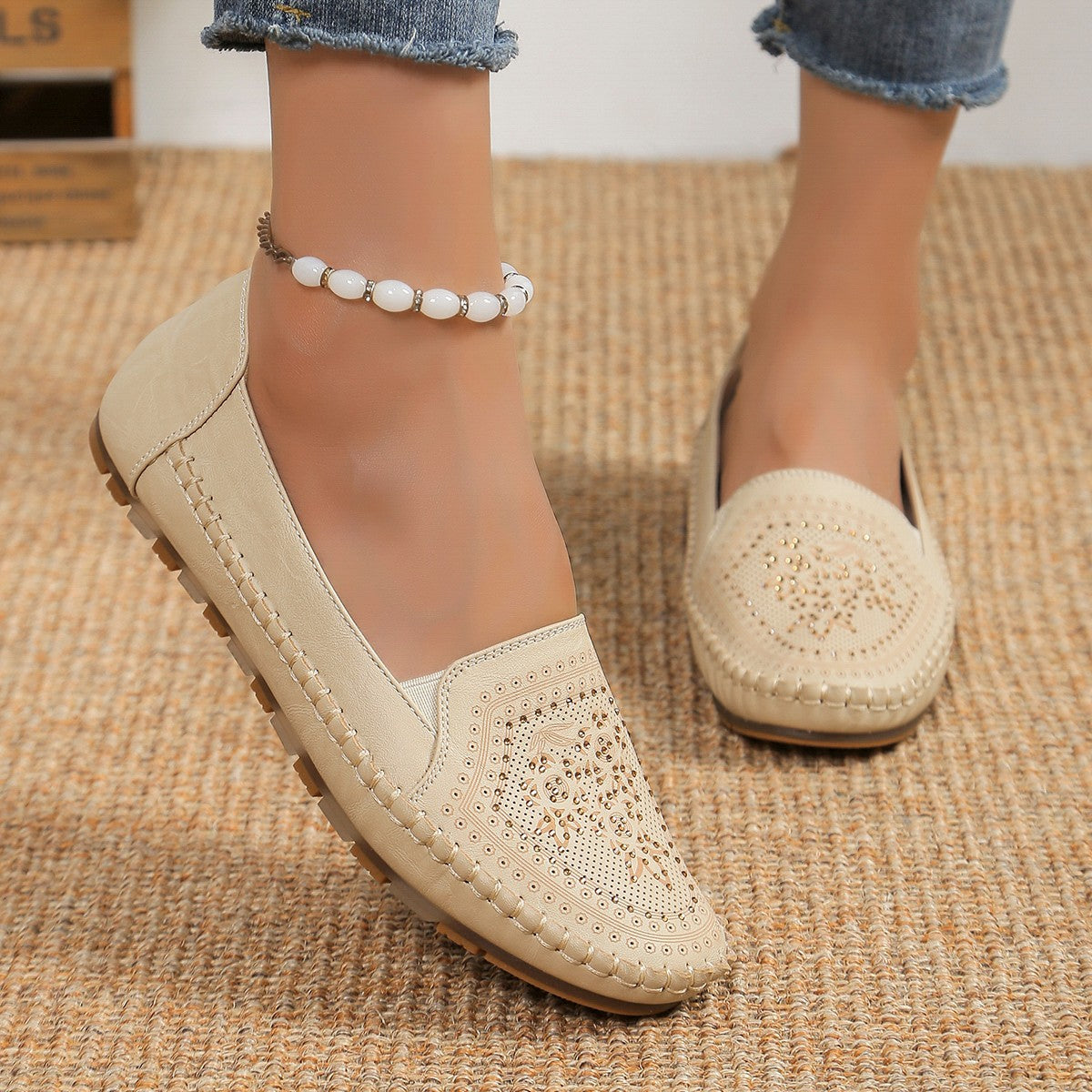 Beige Damen-Loafer mit Lochmuster, Perlenfußkettchen, Jeans. Bequeme, stilvolle Schuhe für Freizeit und Alltag. Ideal für Sommermode.