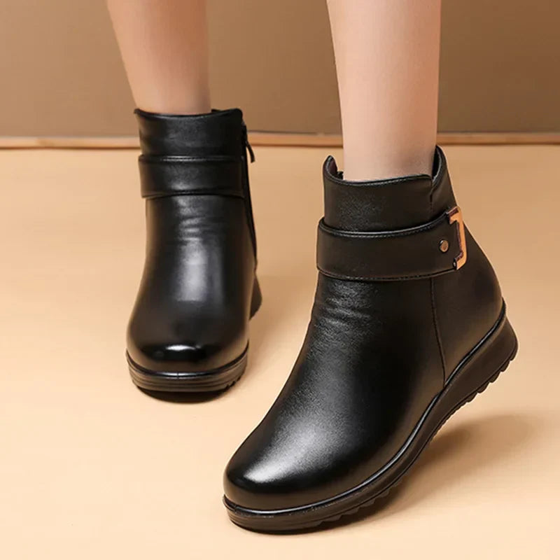 Schwarze Damenstiefeletten aus Leder mit seitlichem Reißverschluss und Schnalle, rutschfeste Sohle, modisch und bequem für Herbst und Winter.