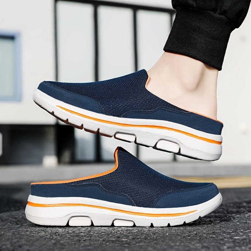 Blaue Herren-Sneaker mit weißer Sohle und orangefarbenem Akzent, getragen auf Asphalt. Bequeme, atmungsaktive Freizeitschuhe für den Alltag.