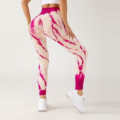 Frau in pink-weiß gemusterten Leggings, Rückansicht, sportlich, modisch, Fitnessbekleidung, weiße Turnschuhe, athletischer Stil, neutraler Hintergrund.
