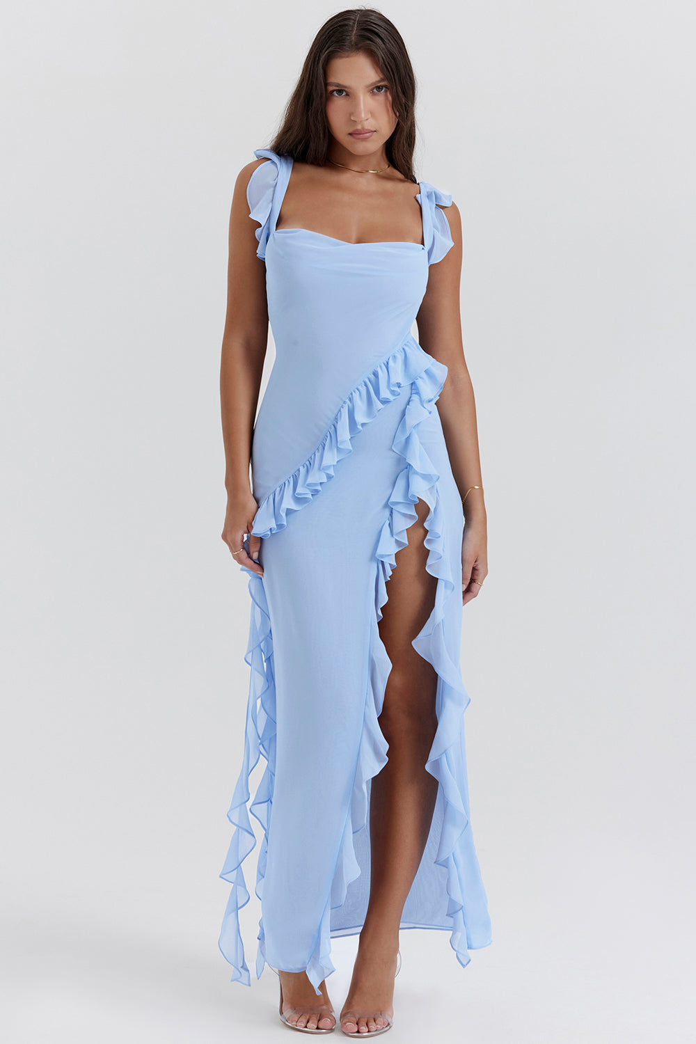 Frau in hellblauem, ärmellosem Kleid mit Rüschen und hohem Schlitz, elegantes Abendmode-Outfit, modisches Design, Sommerkleid.