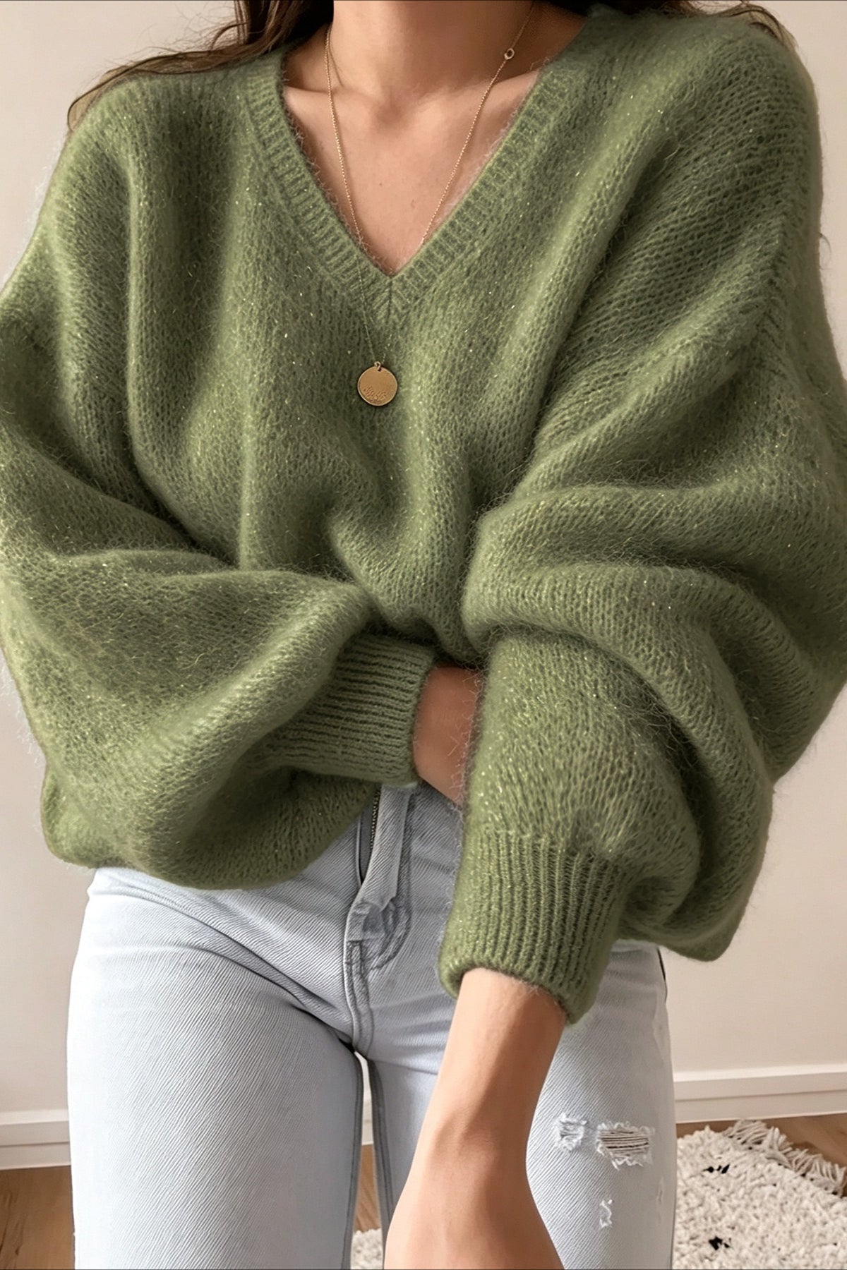 Frontansicht eines oversized Strickpullovers in Olivgrün mit V-Ausschnitt und Ballonärmeln