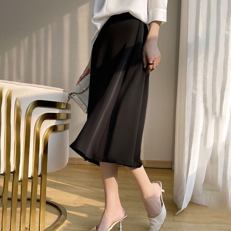 Elegante Frau in schwarzem Midirock und weißen High Heels, steht neben modernem Stuhl. Stilvolle Mode, minimalistisches Design, Innenraum.